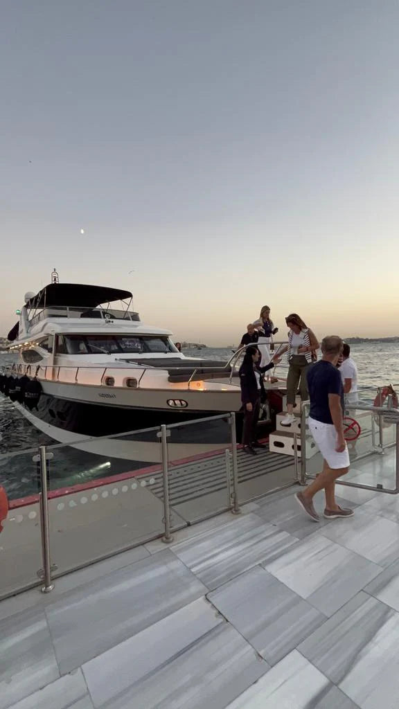 Family enjoying sunset on deck of Istanbul-based luxury yacht.