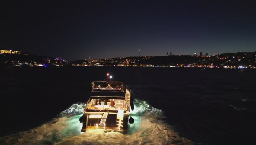 Nighttime luxury yacht , with Istanbul's illuminated skyline providing a dramatic setting