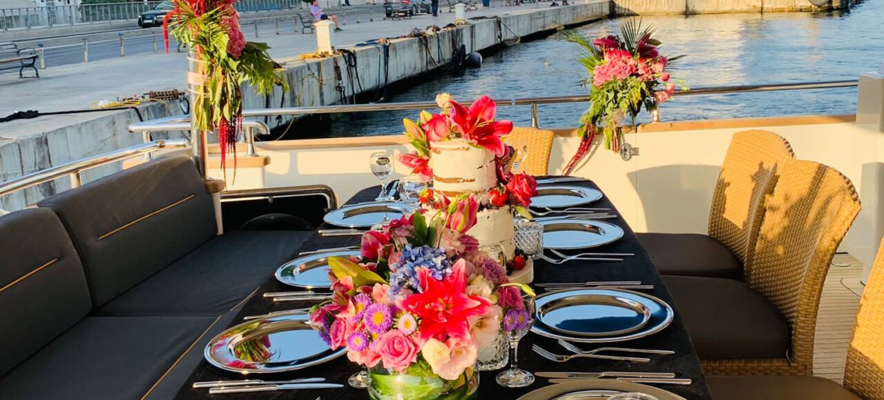 private-yacht-sunset-dinner-table-setting-bosphorus Elegant dinner table setup on a luxury yacht featuring grilled fish and mezes at sunset.